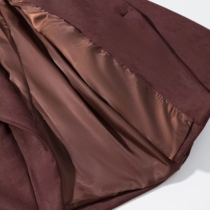 Detailed view of dark burgundy faux suede jacket showing glossy satin lining and fabric texture
