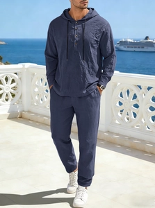 Detail of dark blue linen hooded shirt and pants set for men in seaside resort setting