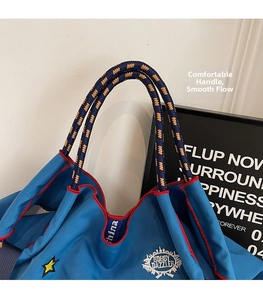 Close-up of canvas tote bag with Bobby Dazzler embroidery and woven rope handles