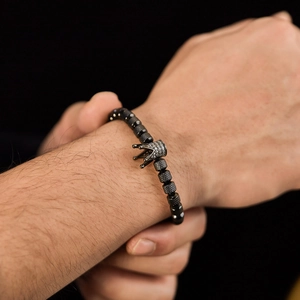 Men's retro beaded bracelet with crown charm and black stones on a model's wrist