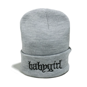Dettaglio del ricamo babygirl su berretto in maglia grigio con trama a coste