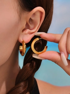 Close-up of elegant gold C-shaped chunky earrings with polished metallic finish