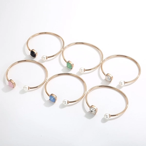 Dettaglio di sei bracciali a C in oro rosa con pietre quadrate e perle in vari colori vivaci