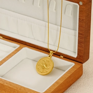 Golden Scorpio zodiac coin necklace with embossed scorpion pendant on stainless steel chain