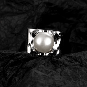 Silver wide band ring featuring a textured hammered finish and a large white round pearl