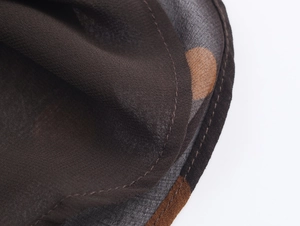 Macro view showing fine hem stitching on dark brown polka dot chiffon fabric detail