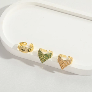 Adjustable gold V-shaped rings with sparkling cubic zirconia on a white display tray