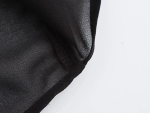 Close-up of black chiffon fabric texture and professional stitching on casual shirt