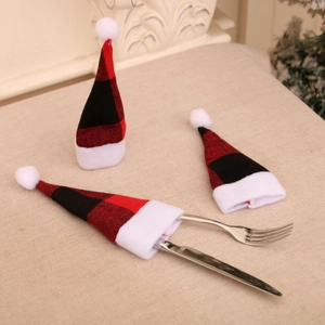 Close-up of three red and black plaid mini Christmas hats used as cutlery holders