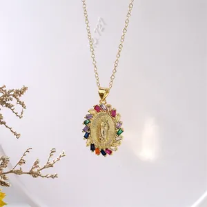 Dettaglio del ciondolo Buddha dorato con cristalli colorati su sfondo bianco materico