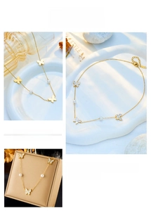 Macro detail of elegant golden necklace featuring pearl accents and white butterfly charms