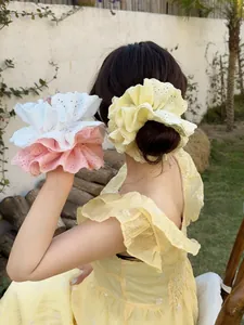 Detail of oversized lace scrunchie featuring delicate eyelash embroidery texture