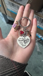 Détail du porte-clés musical avec pendentif cœur gravé et breloque guitare colorée