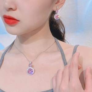 Model wearing a pink zircon necklace and matching earrings set with silver-tone settings
