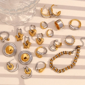 Detailed flat lay of two-tone gold and silver earrings, rings, and link bracelet accessories