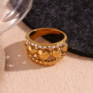 Macro detail of triple-layer 18K gold-plated ring with beads and crystals texture