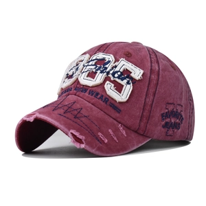 Macro detail of washed cotton baseball cap with vintage 985 embroidery and distressed brim