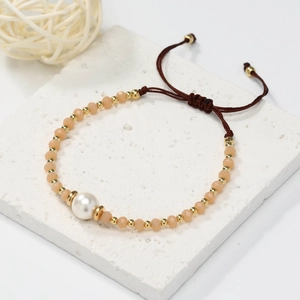 Detailed macro view of handmade peach crystal beads with large pearl on woven rope strap