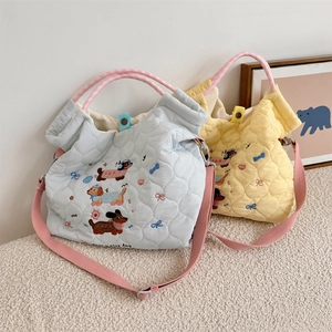 Detail of cute dog embroidery and quilted fabric texture on a soft shoulder bag