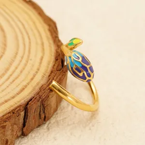 Adjustable 18K gold-plated stainless steel ring with colorful leaf enamel on wood base