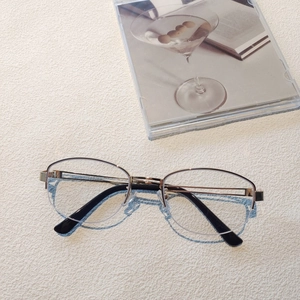 Detail of premium half-frame oval glasses in black and gold finish on minimalist background