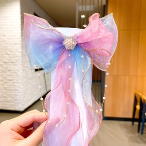 Detailed view of pink and blue gradient organza bow with pearl tassel and crystal flower