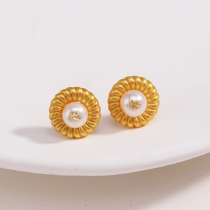 Détail macro de boucles d'oreilles fleur de lave plaquées or 18k avec perle blanche