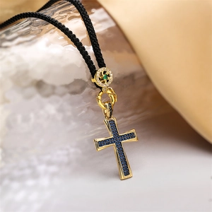 Cross pendant necklace with gold plating, blue zircon accents and green center stone
