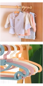 Detail view of colorful plastic baby clothes hangers in macaron blue and pink shades