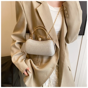 Detail of silver glitter evening clutch bag with gold round handle and rhinestone clasp