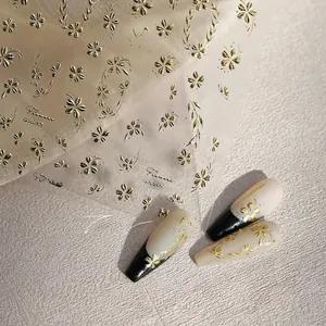 Detail of golden embossed floral nail stickers on a clear sheet with a 3D textured finish