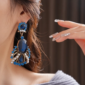 Macro shot of vintage style earrings with blue gems and white pearls on a copper base