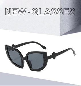 Detail of black cat-eye sunglasses with unique pointed temples on abstract background