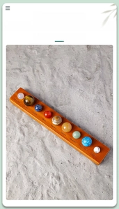 Solar system crystals set on wooden base with engraved planet names over gravel