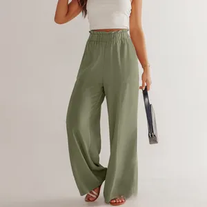 Dettaglio dei pantaloni in cotone e lino verde erba con vita alta elastica e tasche laterali