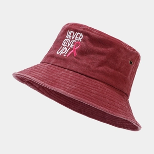 Détail de la broderie NEVER GIVE UP et ruban rose sur ce chapeau bob rouge foncé