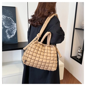 Detail of khaki quilted nylon tote bag with drawstring closure and puffy texture