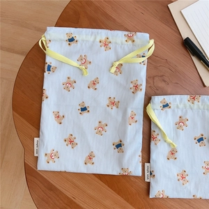 Detailed view of blue striped drawstring storage bag with cute cartoon bear pattern