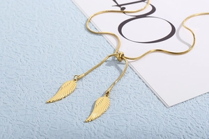 Detail of gold angel wing pendant on snake chain with adjustable bead clasp
