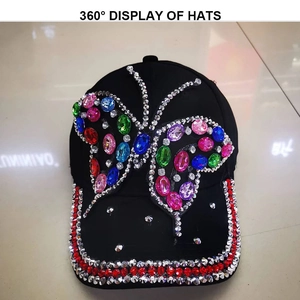 Detailed close-up of colorful rhinestones and butterfly patterns on a black denim baseball cap