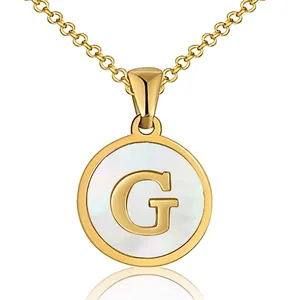 Detail of round golden necklace with letter G pendant and iridescent shell inlay