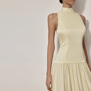 Vue détaillée d'une robe longue sans manches en satin jaune pâle avec jupe plissée