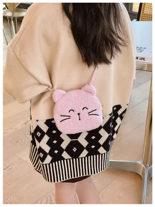 Detail of pink plush cat crossbody bag with embroidered facial features for children