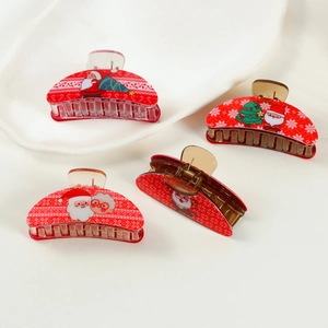 Set of four red Christmas claw clips featuring Santa and holiday tree patterns on white tray