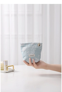 Detail of light blue swan jacquard makeup bag featuring a decorative gold flower zipper