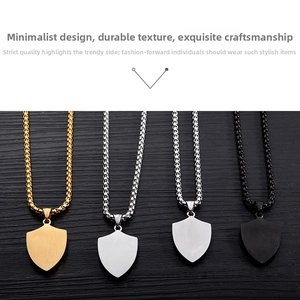 Detailed close-up of shield-shaped titanium steel pendants in gold, silver, and black finishes