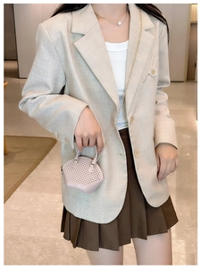Detailed view of pink mini woven handbag paired with beige blazer for a stylish look
