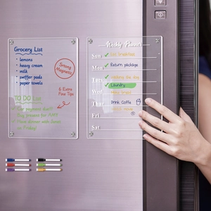 Close-up of magnetic acrylic weekly planner with markers on a refrigerator door