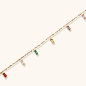 Detail of gold chain with multicolored rectangular zircon pendants in elegant minimalist design