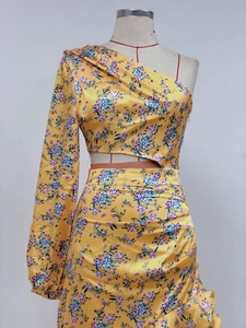 Close-up of yellow floral bodycon dress featuring hollow-out waist and ruffled hem details